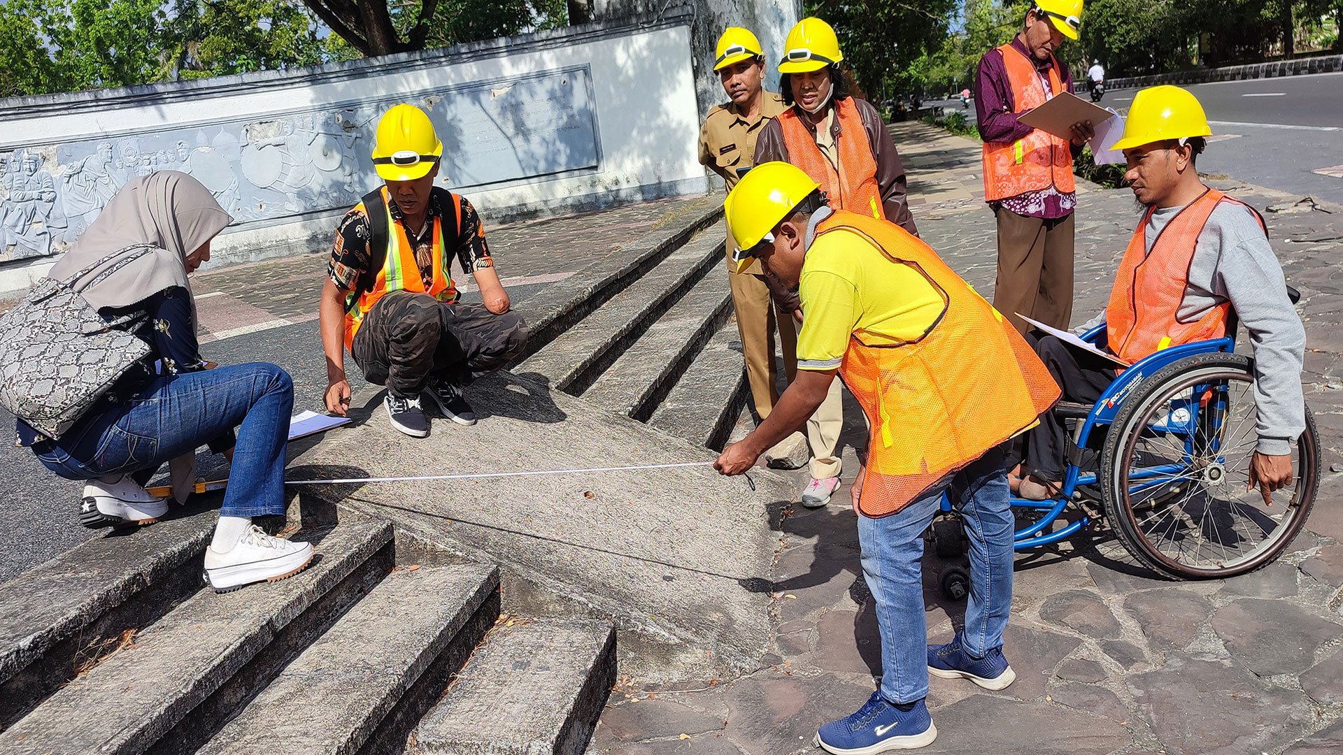 Group of people wearing hardhats measuring an access ramp