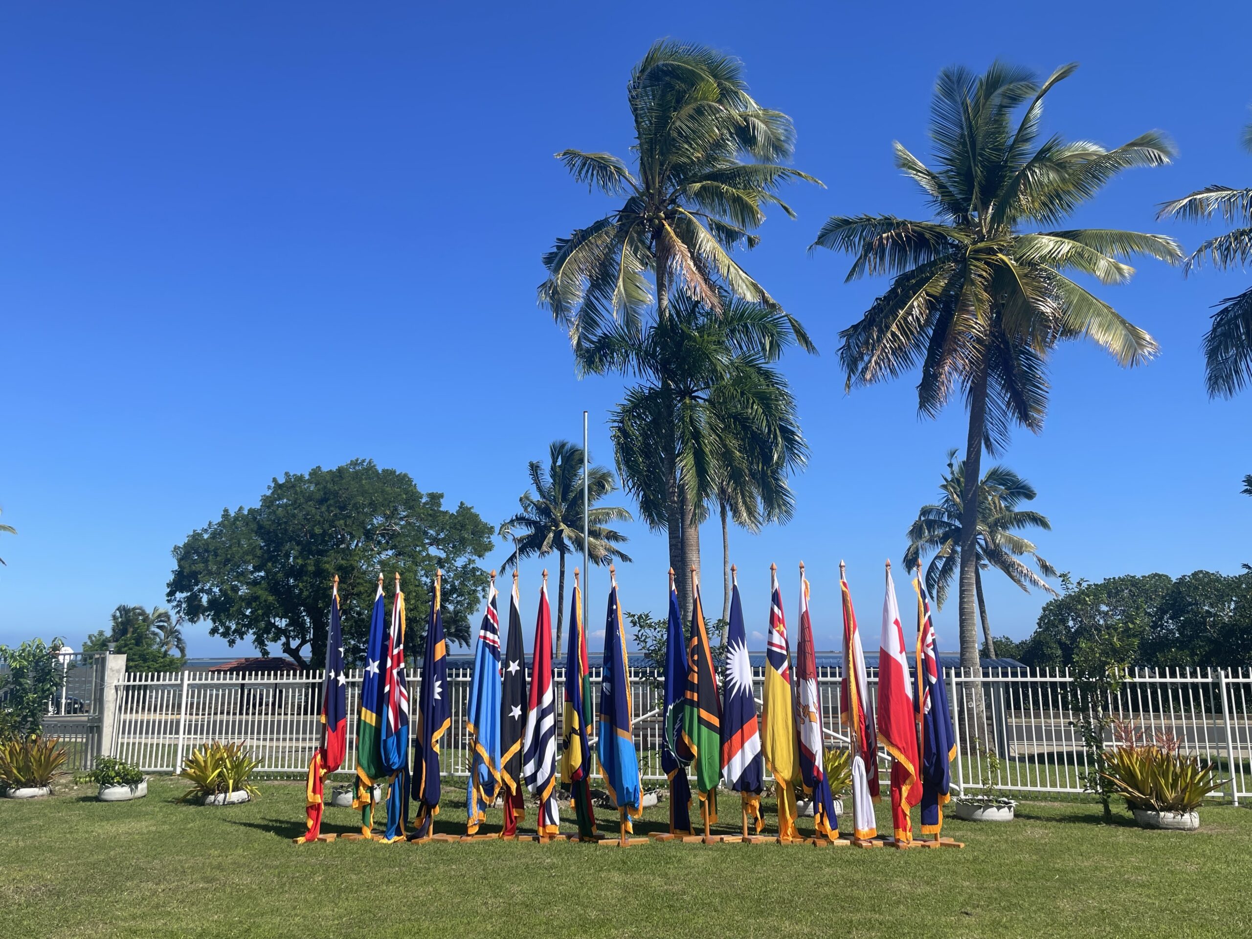 Multiple national flags hanging, lined up in a row outdoors