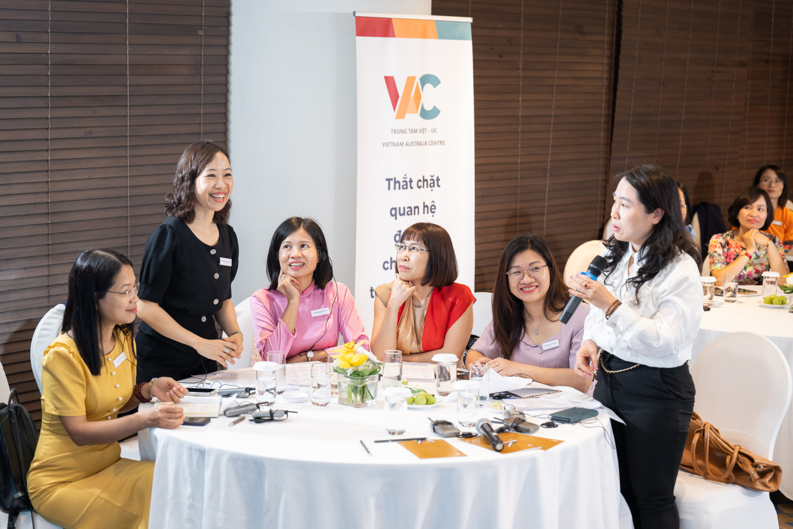 Women sitting a table for a WILJ6 training activity