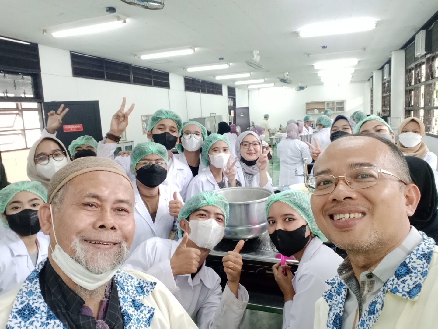 Eko Hari Purnomo poses for a group photo with his students after a food processing practice session at IPB's laboratory.