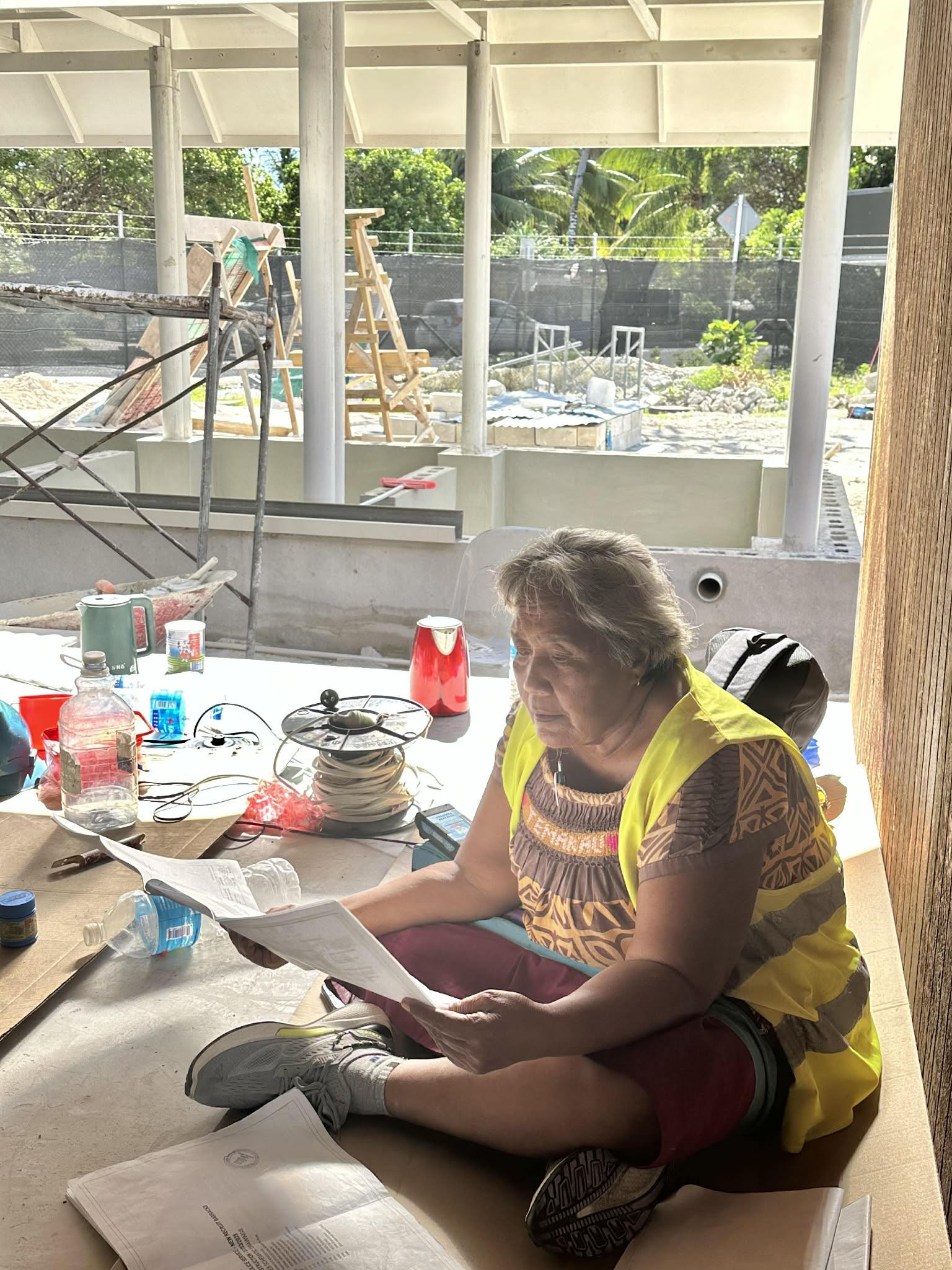 Naomi reviewing project plans on site in Kiribati