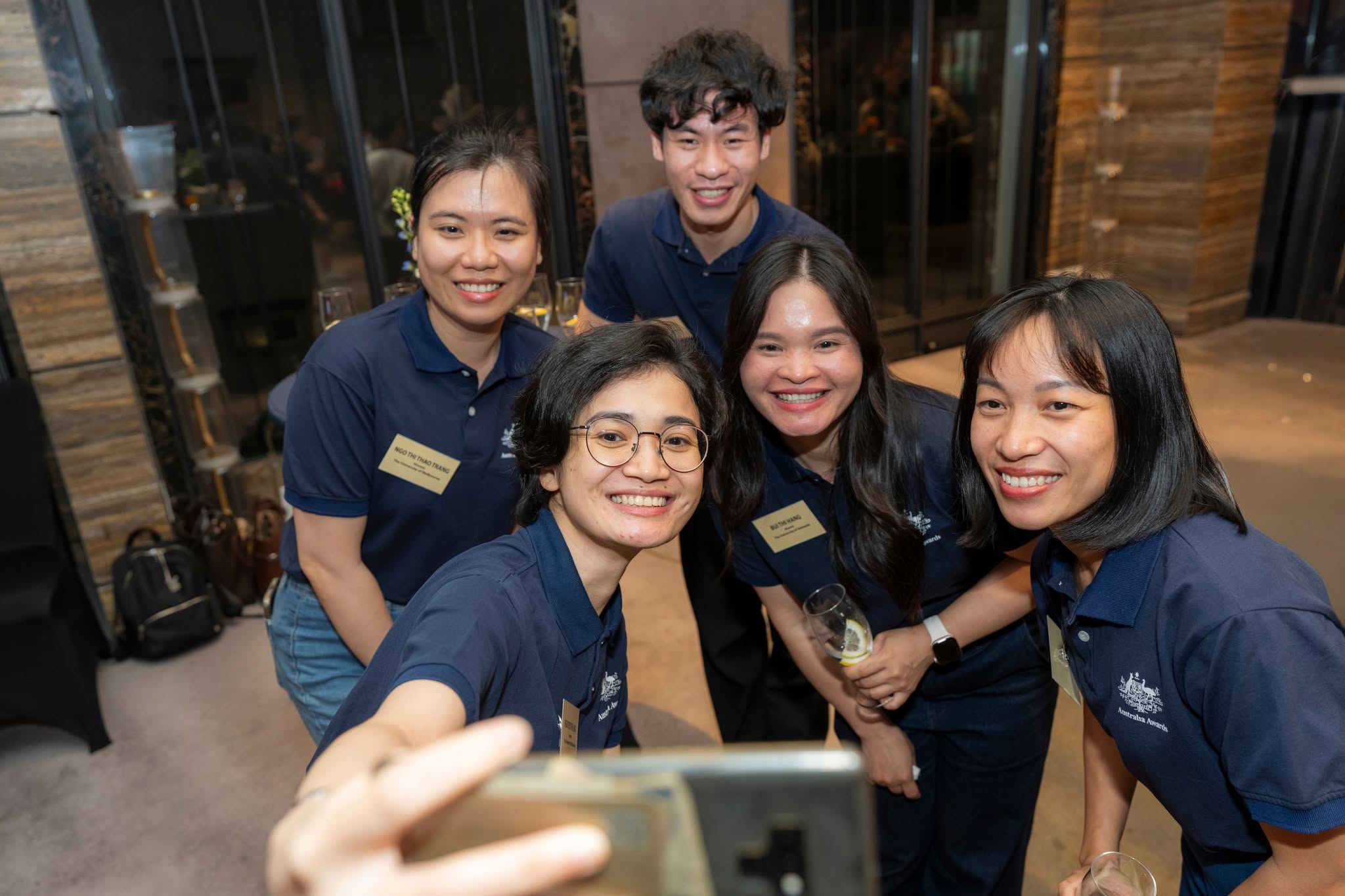 Group of five Australia Awards graduates taking a selfie together