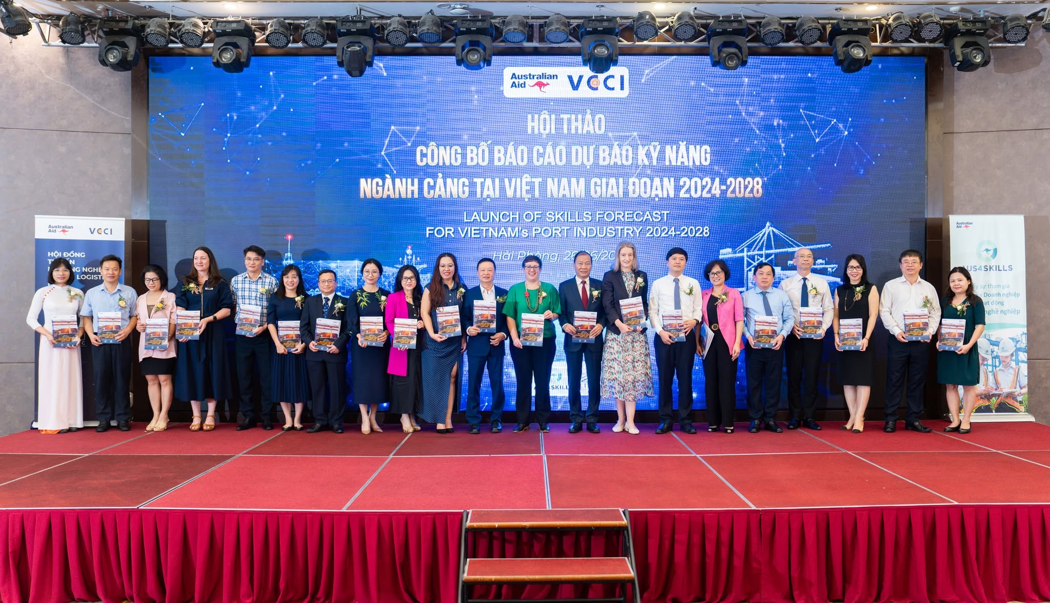 Group standing on stage in a line each holding a copy of Vietnam’s first Industry Skill Forecast Report